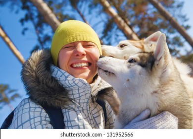 Young Woman Emracing Sled Dogs