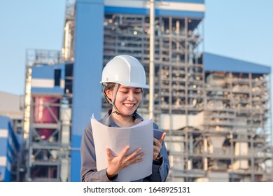 Young Woman Engeneer Smile Was Standing And Wearing Safety Helmet,  Have Drawing In Your Hand With Power Plans  Background.