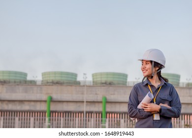 Young Woman Engeneer  Was Standing And Wearing Safety Helmet,  Have Drawing In Your Hand Withtower Cooling Of  Power Plans  Background.