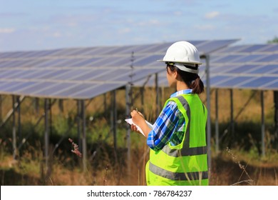 Young Woman Engineer Checking Solar Panel At Solar Power Plant