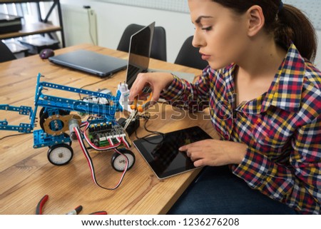 Young woman engineer working on robotics project. Startup concept