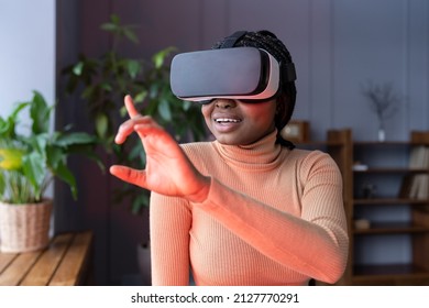 Young Woman Enjoy Vr Gaming, Using Virtual Reality Interface For Shopping Wearing Goggles At Home. African Lady Excited First Virtual Reality Experience Try To Touch Objects In Digital Simulation App