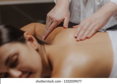 Young woman enjoying a back massage in a spa center.