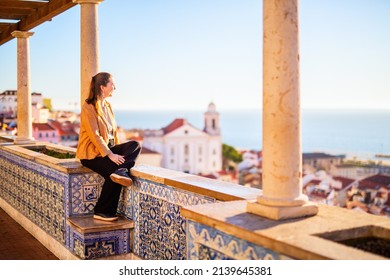 Young woman enjoying breathtaking view over central Lisbon in Portugal from beautiful terrace decorated with traditional portuguese tiles azulejos