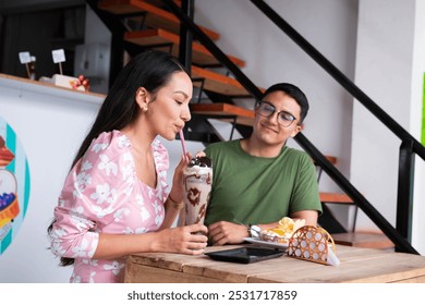 Young woman enjoying a delicious milkshake with her boyfriend - Powered by Shutterstock