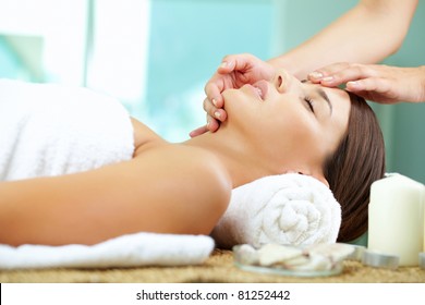 Young Woman Enjoying Facial At Spa Salon