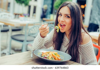 Young Woman Enjoying Food In A Restaurant, Having Her Lunch Break. Close Up