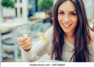 Young Woman Enjoying Food In A Restaurant, Having Her Lunch Break. Close Up