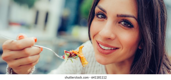 Young Woman Enjoying Food In A Restaurant, Having Her Lunch Break. Close Up