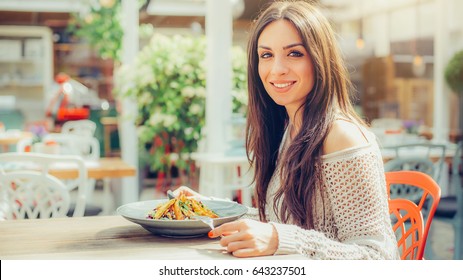 Young Woman Enjoying Food In A Restaurant, Having Her Lunch Break. Close Up