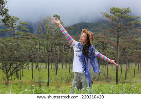 Young woman enjoying the fresh air in green forest. 
