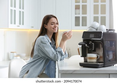 Young woman enjoying fresh aromatic coffee near modern machine in kitchen - Powered by Shutterstock