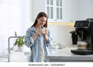 Young woman enjoying fresh aromatic coffee near modern machine in kitchen - Shutterstock ID 2101665967