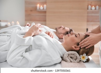 Young woman enjoying head massage in spa salon
