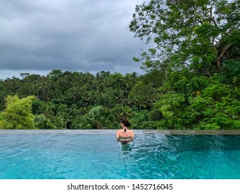 Young Woman Enjoying An Infinity Pool Overlooking The Jungle