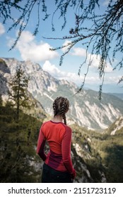 Young woman is enjoying mountains from a view point in Julian Alps on a beautiful sunny September day.