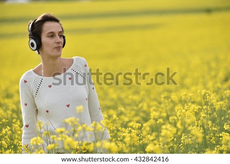 Young woman enjoying music in the headphones in the outdoors