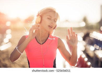 Young woman enjoying music on the beach