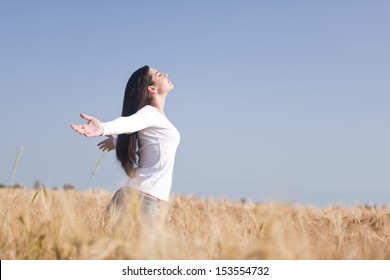 Young woman enjoying nature, arms raised