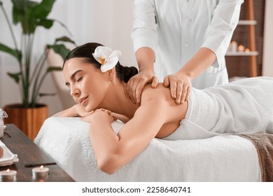 Young woman enjoying professional massage in spa salon - Powered by Shutterstock