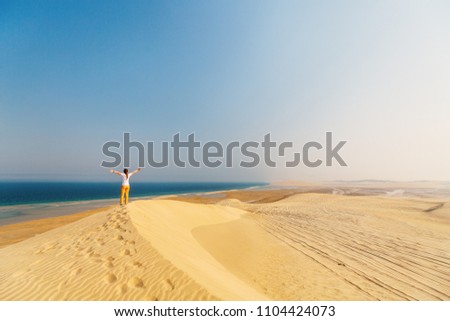 Young woman enjoying sand dunes in Qatar desert