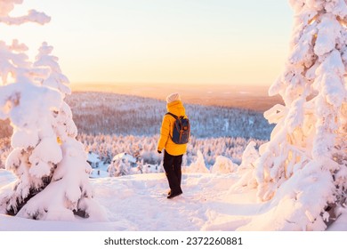 Young woman enjoying stunning view over winter forest with snow covered trees in Lapland Finland