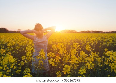 young woman enjoying summer and nature in yellow flower field at sunset, harmony and healthy lifestyle - Shutterstock ID 368167595