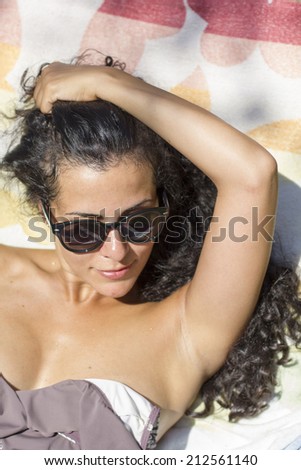 Brunette surfer woman in bikini standing with surfboard