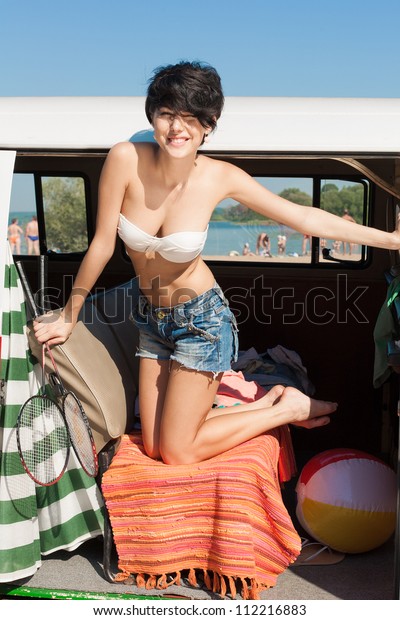 Young woman enjoying the sun in car near the\
beach - outdoors