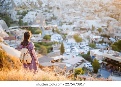 Young woman enjoying sunset view over Goreme town in Cappadocia