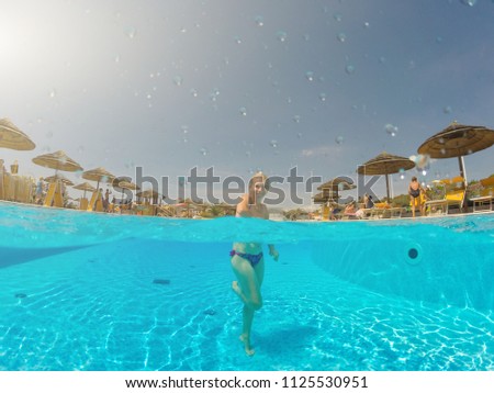 Young woman enjoying in the swimming pool in the hot sunny day. Holiday Concept