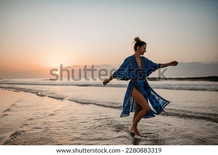 Young woman enjoying time at sea, dancing.