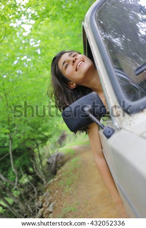 Young woman enjoying to the travel in the nice forest with her boyfriends classic car.