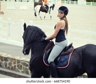 Young Woman In Equestrian Outfit Riding A Horse.