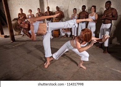 Young woman evades a kick during a Capoeira demonstration
