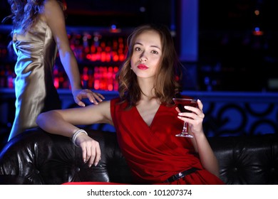 Young woman in evening dress in night club with a drink - Shutterstock ID 101207374