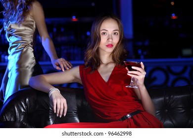 Young woman in evening dress in night club with a drink - Shutterstock ID 96462998