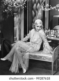 Young Woman In An Evening Gown Sitting On An Upholstered Bench