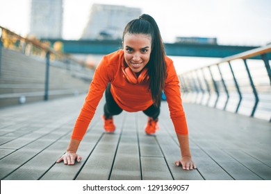 Young woman exercises on the promenade after running in the morning