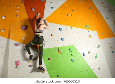 Young woman exercising in climbing gym - Powered by Shutterstock