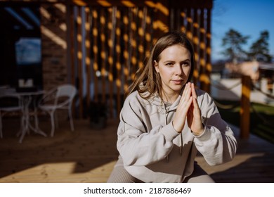 Young Woman Exercising, Doing Yoga And Stretching Outside On Terrace At Home.