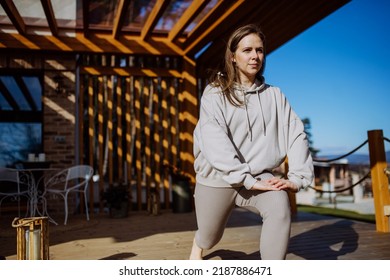 Young Woman Exercising, Doing Yoga And Stretching Outside On Terrace At Home.