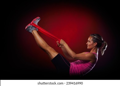 Young Woman Exercising With Elastic Fitness Band In The Gym