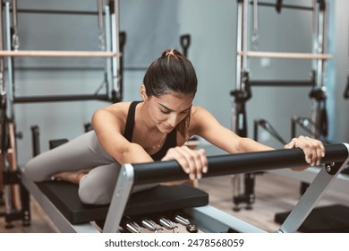 Young woman exercising in a gym on pilates machines. - Powered by Shutterstock