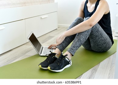 Young Woman Exercising At Home Doing Yoga And Looking At Her Tablet Computer, Home Exercise Workout.