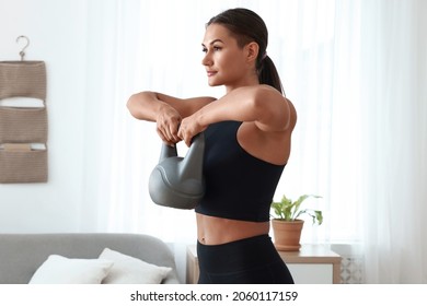 Young Woman Exercising With Kettlebell At Home