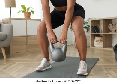 Young Woman Exercising With Kettlebell At Home, Closeup