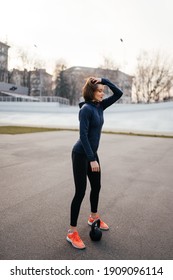 Young Woman Exercising With A Kettlebell Outside At Stadium