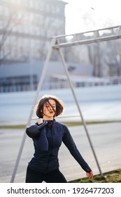 Young Woman Exercising With A Kettlebell Outside At Stadium