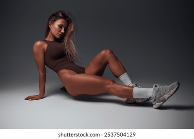 young woman exercising on the floor. blonde in tracksuit posing lying and standing in different positions. playing with muscles. bodybuilding - Powered by Shutterstock